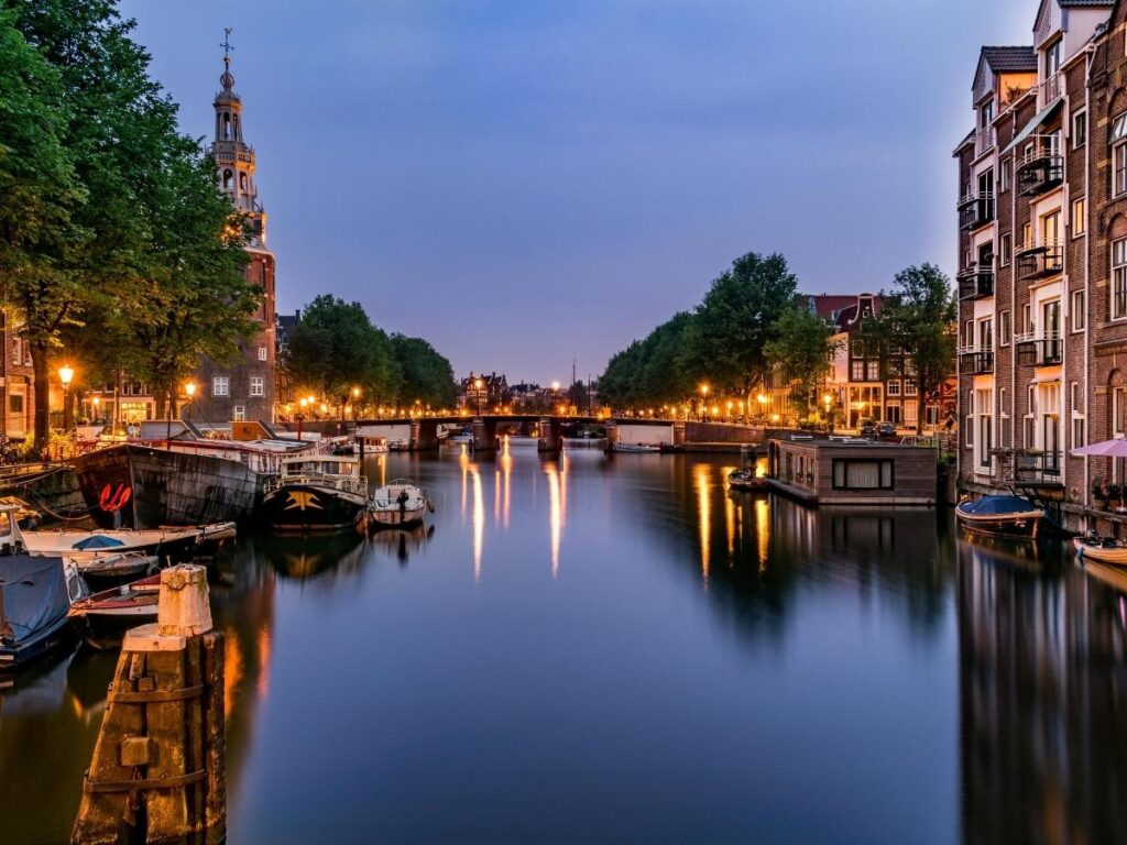 Quiet canal in Cannaregio at dusk with reflections of pastel houses