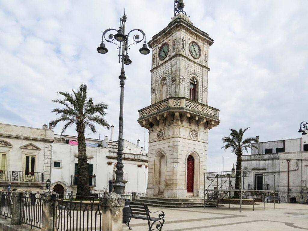Central piazza and castle in Ceglie Messapica on a sunny afternoon.