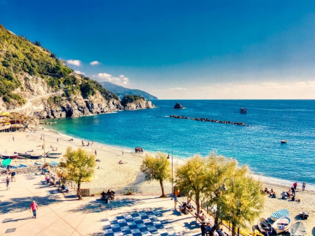 Small rocky cove with clear turquoise water and a swimmer diving from a ledge.