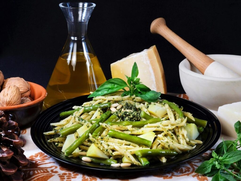 Lunch in Corniglia: a plate of trofie al pesto on a sunlit piazza table.