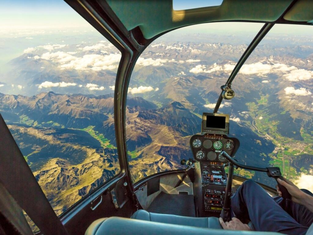 Aerial helicopter view of Mount Etna’s smoking craters and wide lava fields stretching to the coast.”