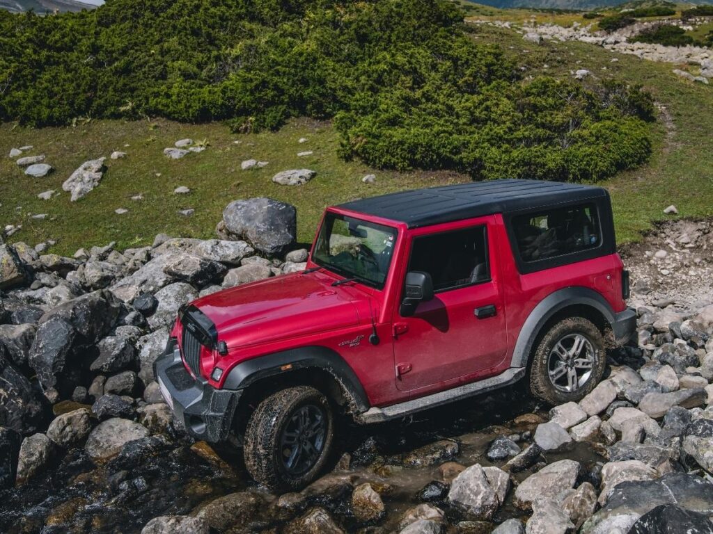 Off-road jeep tour crossing rugged lava fields with Mount Etna in the background.