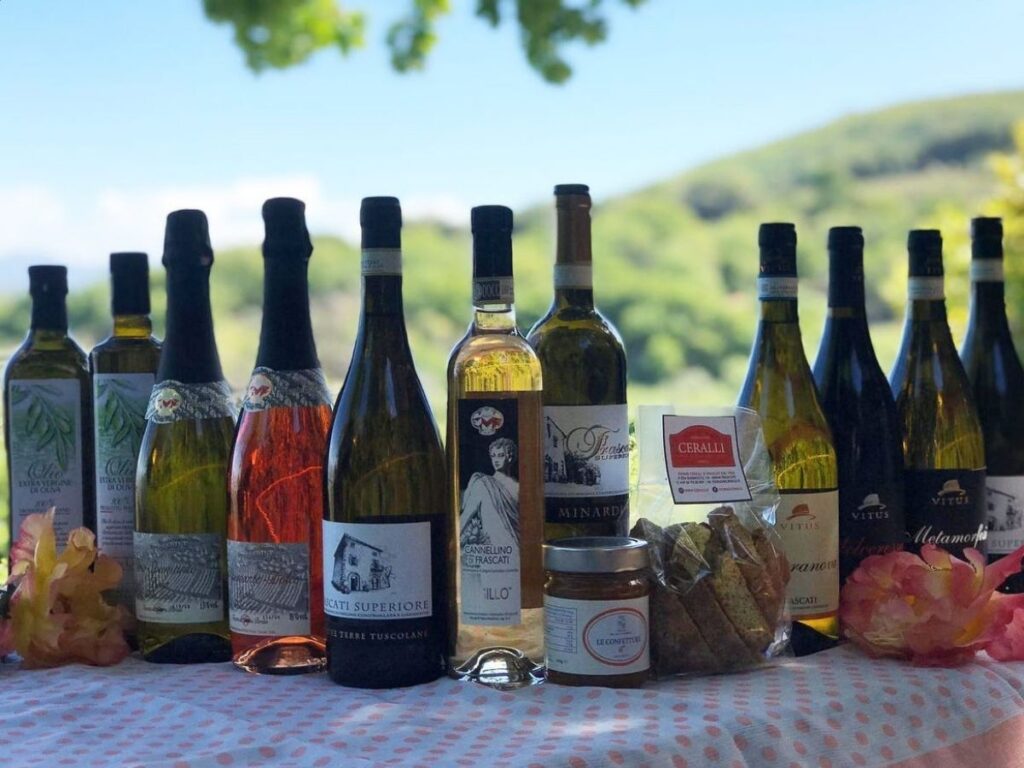 Wine glasses on a table at a Frascati winery with vineyard rows behind