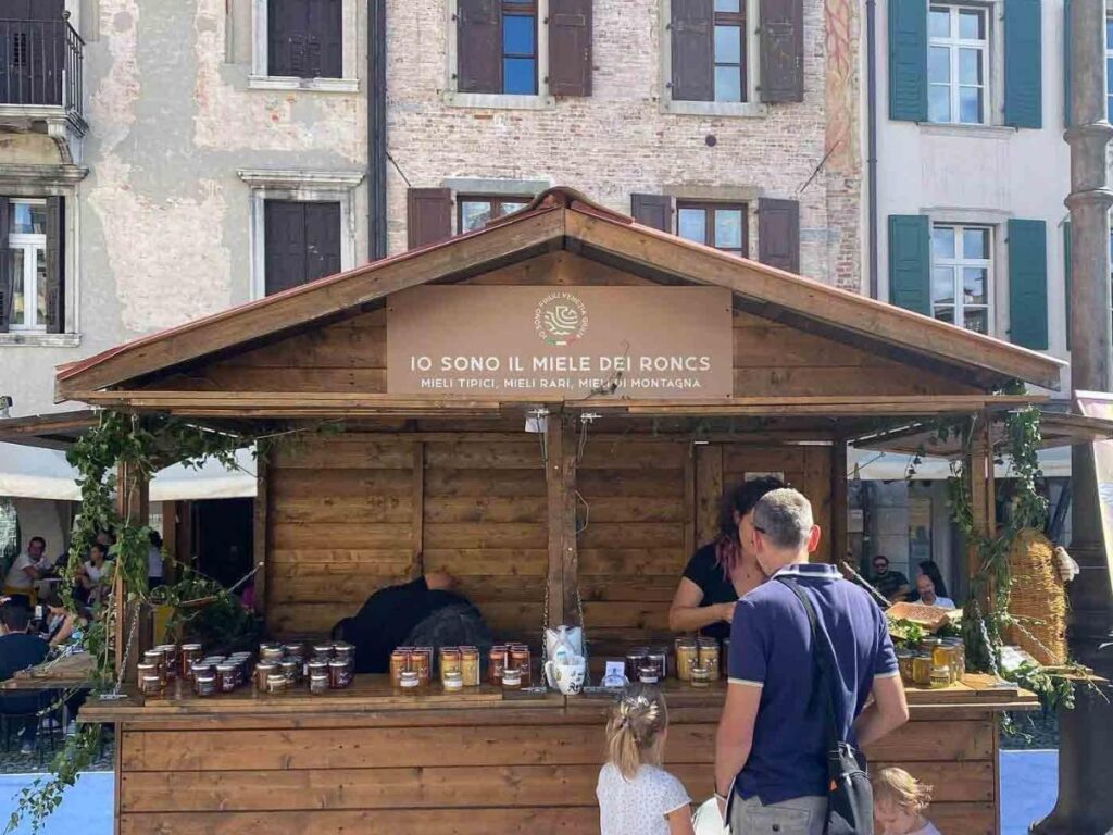 Crowded Friuli Doc food and wine stalls in Udine’s square with visitors tasting local products