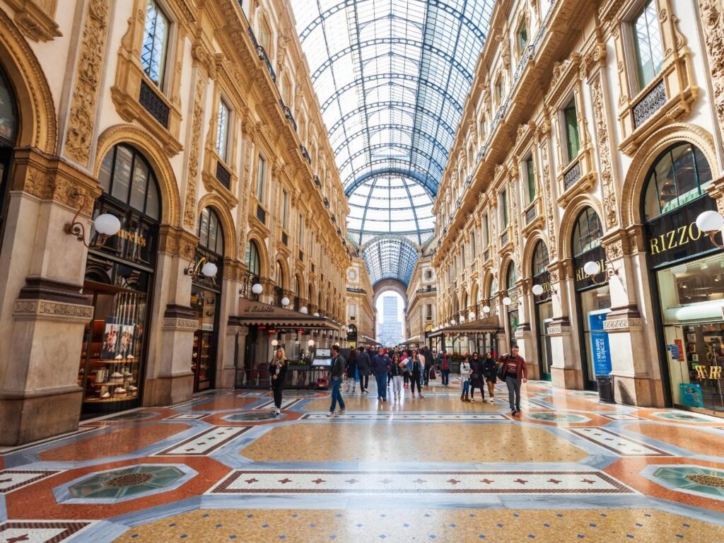 Interior of Galleria Vittorio Emanuele II with glass dome and elegant shops.