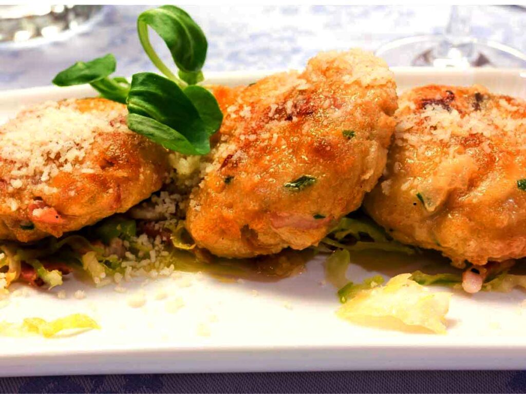 Traditional Ladin dish of canederli dumplings served with butter in the Dolomites.