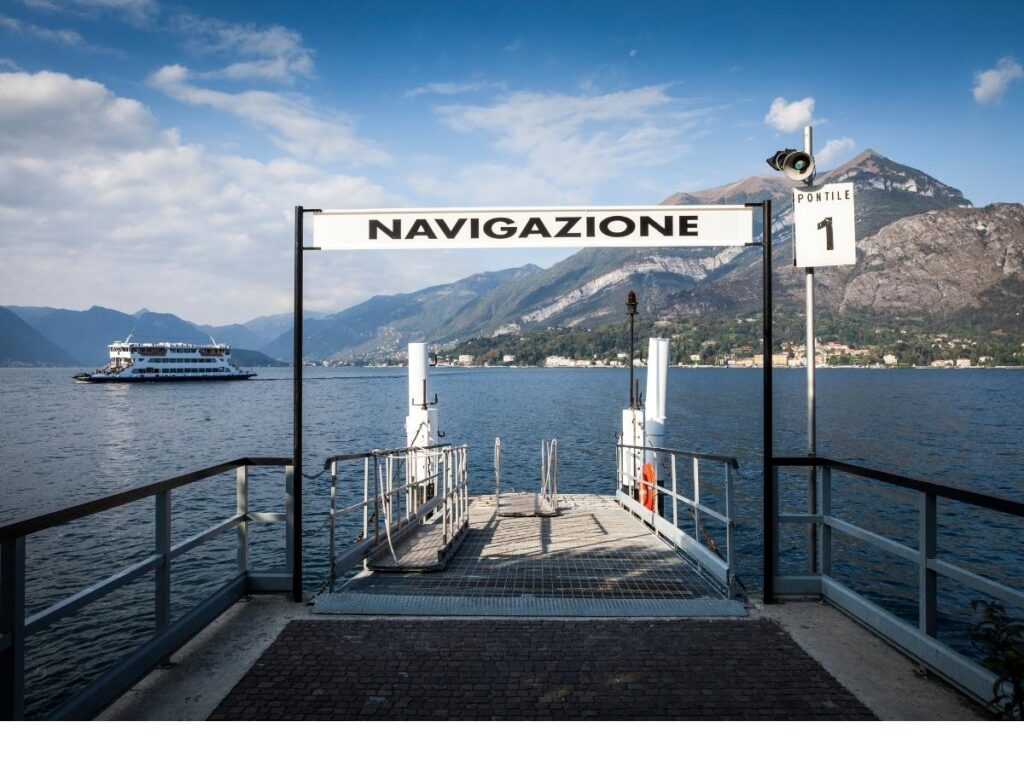 Ferry approaching Bellagio with pastel houses along Lake Como shore.