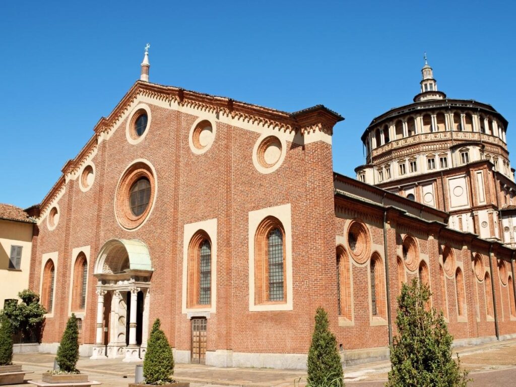 Exterior of Santa Maria delle Grazie with visitors waiting outside for Last Supper entry.