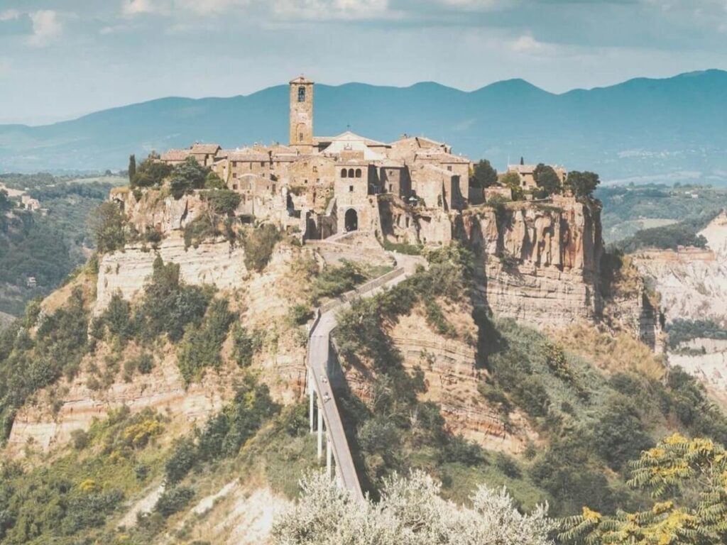 Scenic country road winding through vineyards and olive groves in Lazio at sunset.