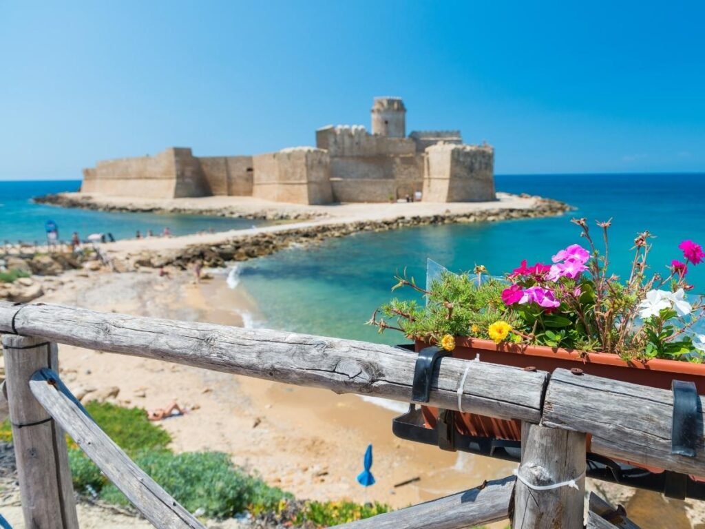 Aragonese castle of Le Castella rising from the Ionian Sea at low tide
