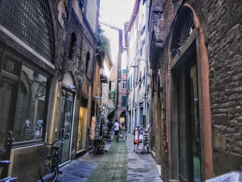 Cyclists on Lucca’s tree-lined city walls overlooking medieval rooftops.