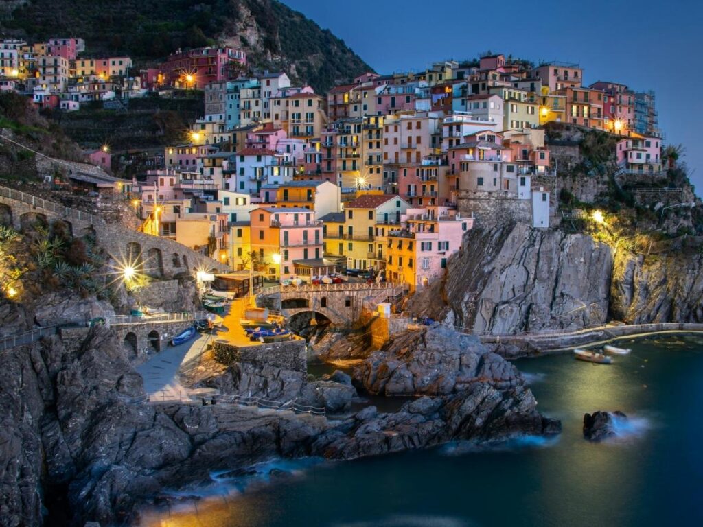 Manarola village glowing in the evening light with houses perched on cliffs above the Ligurian Sea.