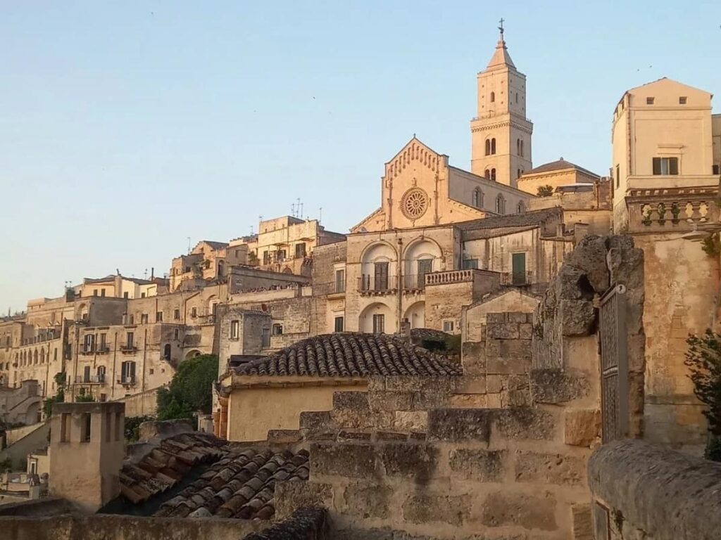 Ancient cave dwellings of Matera lit up at dusk.