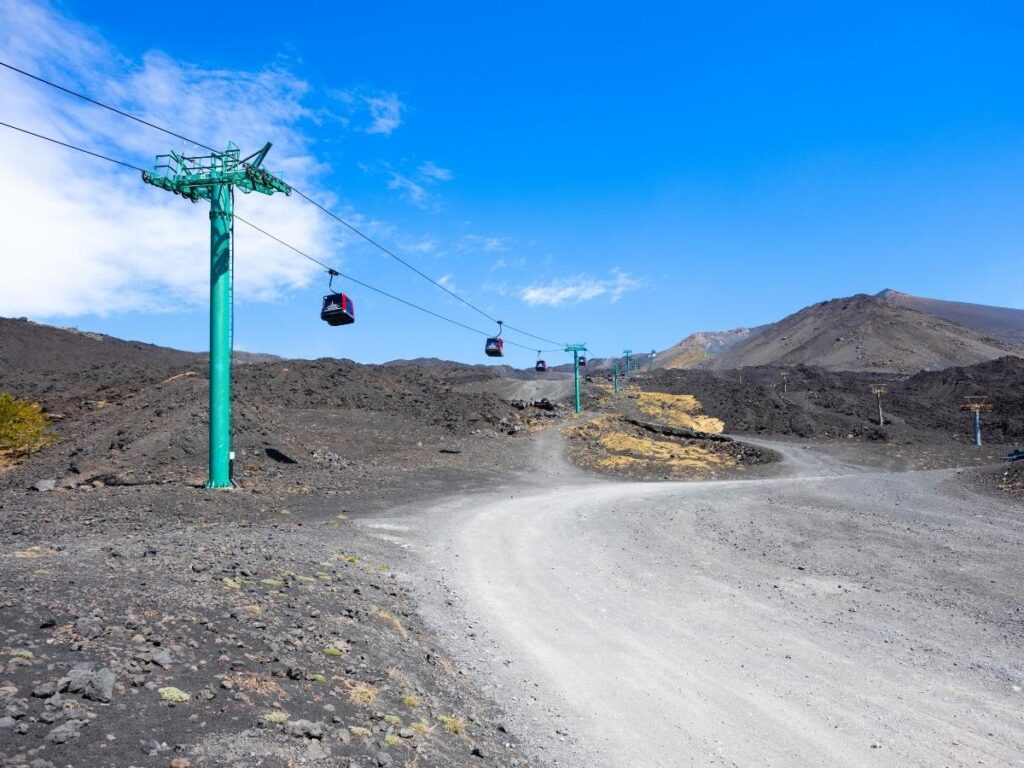 Funivia dell’Etna cable car climbing above black lava fields near Rifugio Sapienza.