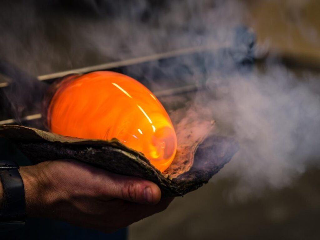 Glassblower shaping molten glass in a Murano workshop