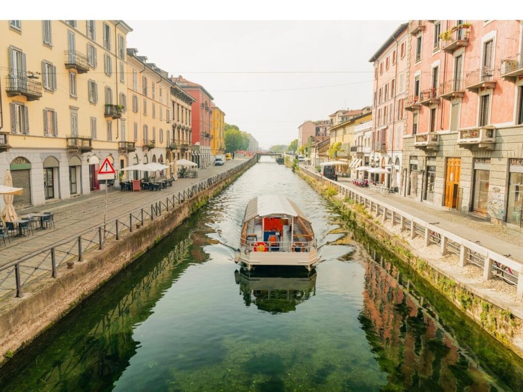 Evenings on the Navigli canals with people enjoying aperitivo at waterside tables.