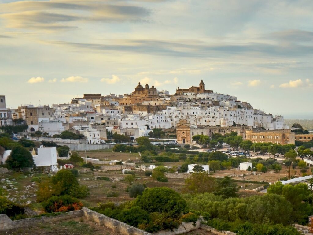 Narrow lane leading up to Ostuni Cathedral with whitewashed walls.