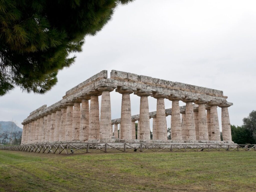 Ancient Doric temple ruins in Paestum at golden hour.