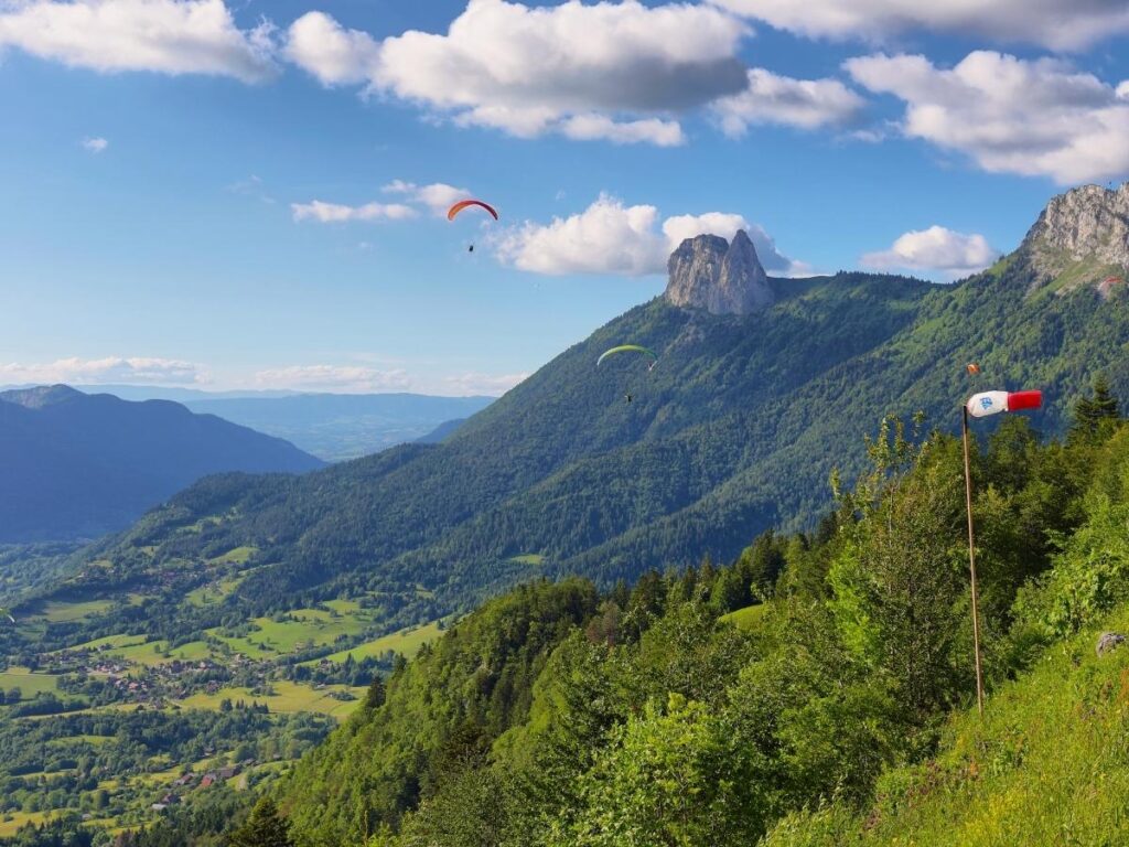 Tandem paraglider flying over Val Gardena with the Seceda ridgeline in the Dolomites.