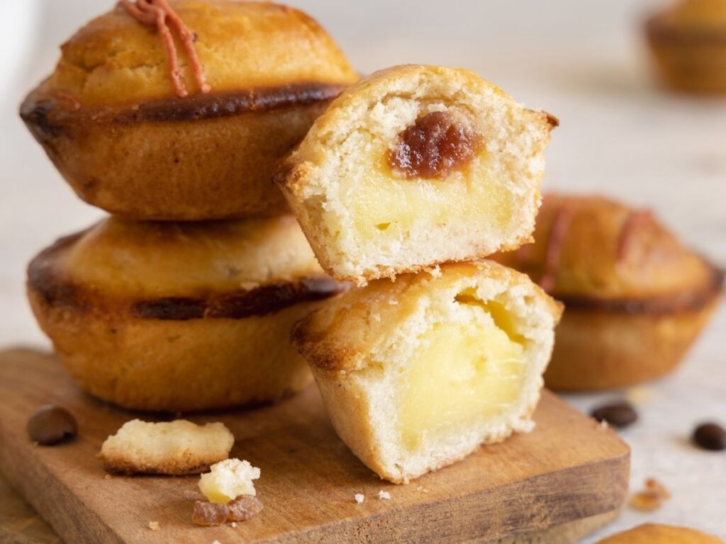 Freshly baked pasticciotti pastries filled with custard on a café table.