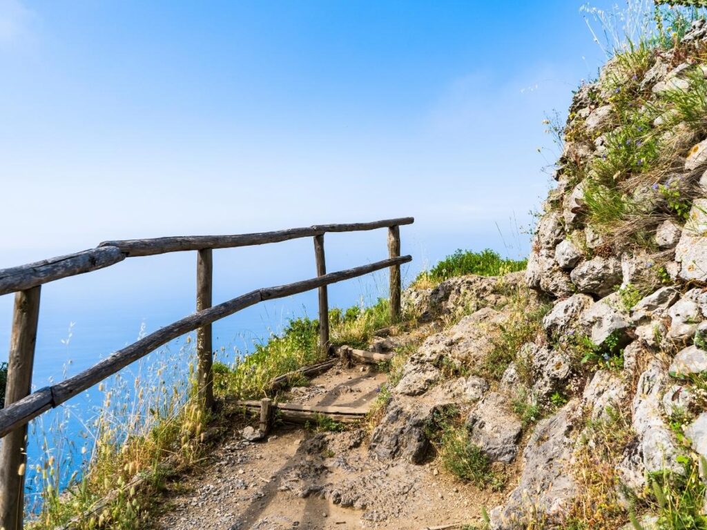 Hiker on the Path of the Gods trail overlooking the Amalfi Coast.