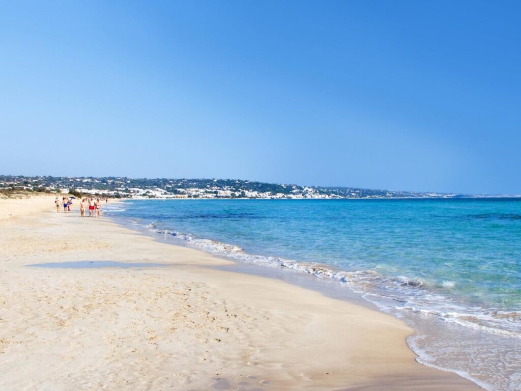 Soft sand and shallow turquoise waters at Pescoluse beach, Apulia.