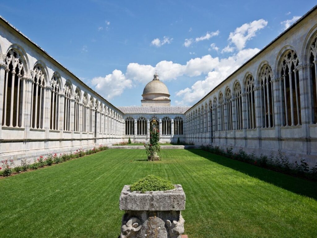 Quiet cloisters of Camposanto in Pisa with frescoes and marble tombs.