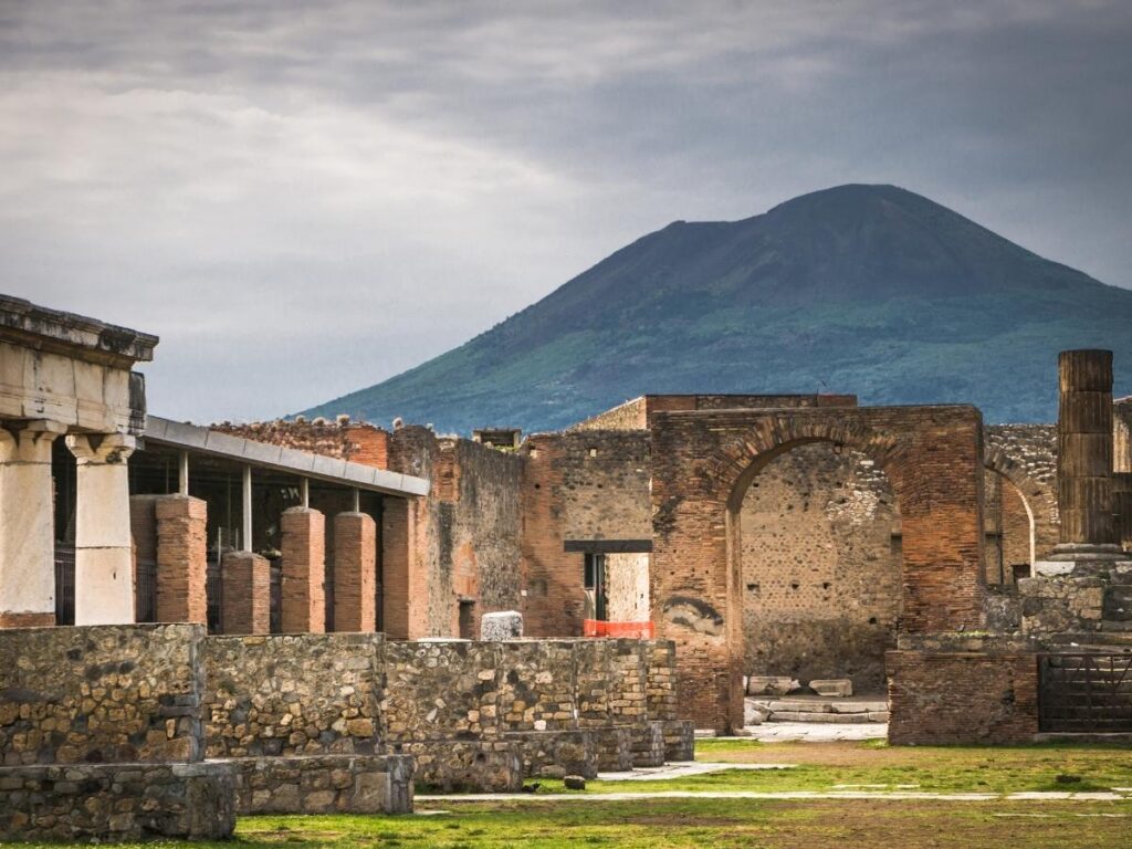 Ancient street in Pompeii with Mount Vesuvius in the distance.