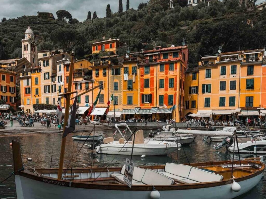 Portofino harbour seen from Castello Brown, with pastel houses curving around turquoise water.