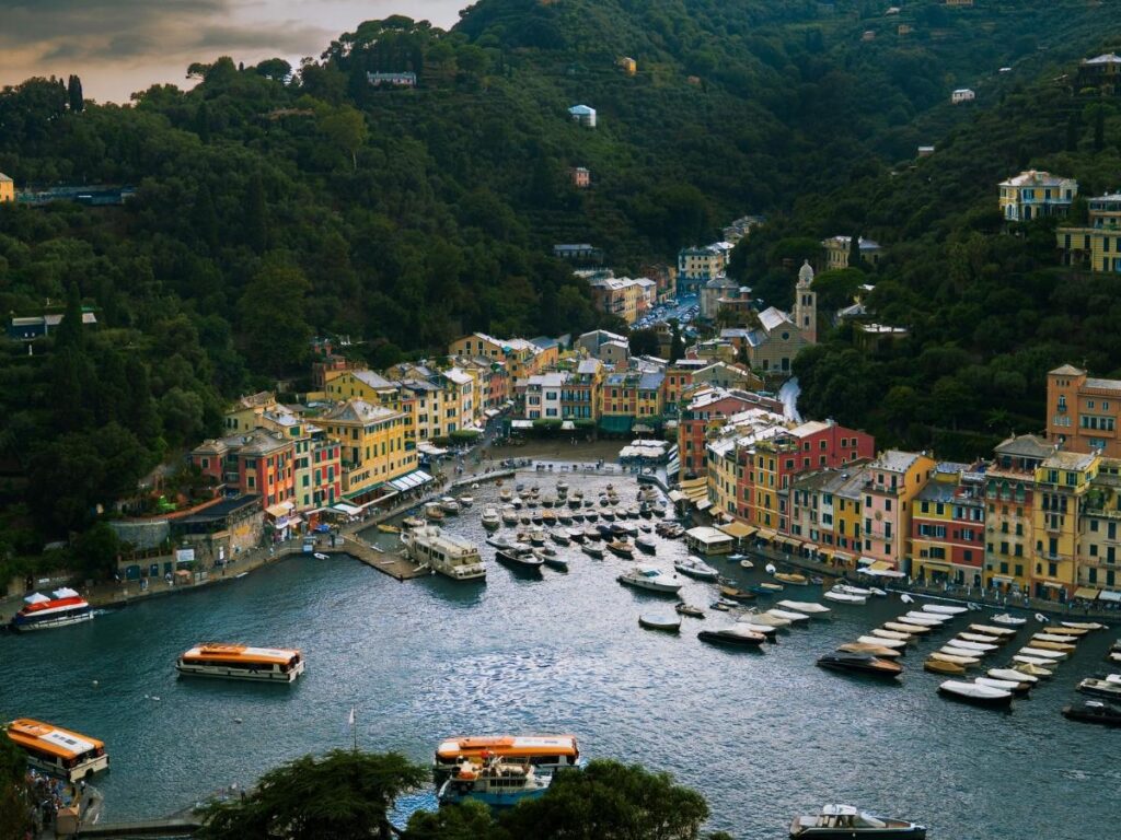Portofino piazzetta at golden hour with pastel houses reflecting in the harbour.
