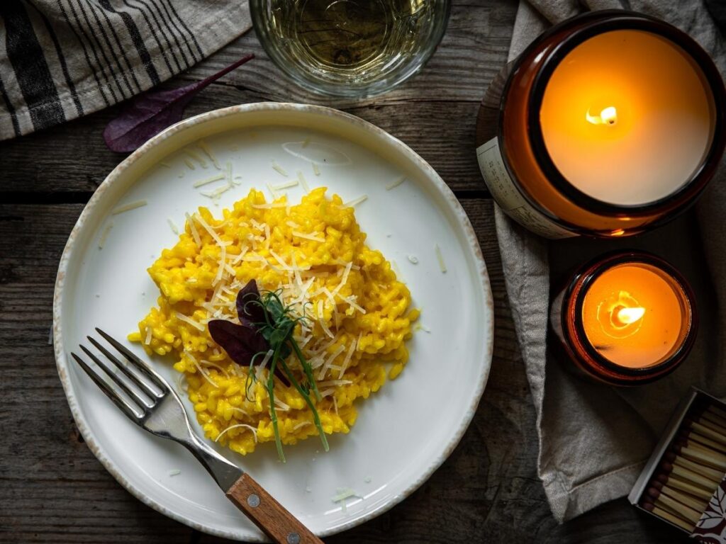Plate of creamy Risotto alla Milanese garnished with saffron and parmesan.