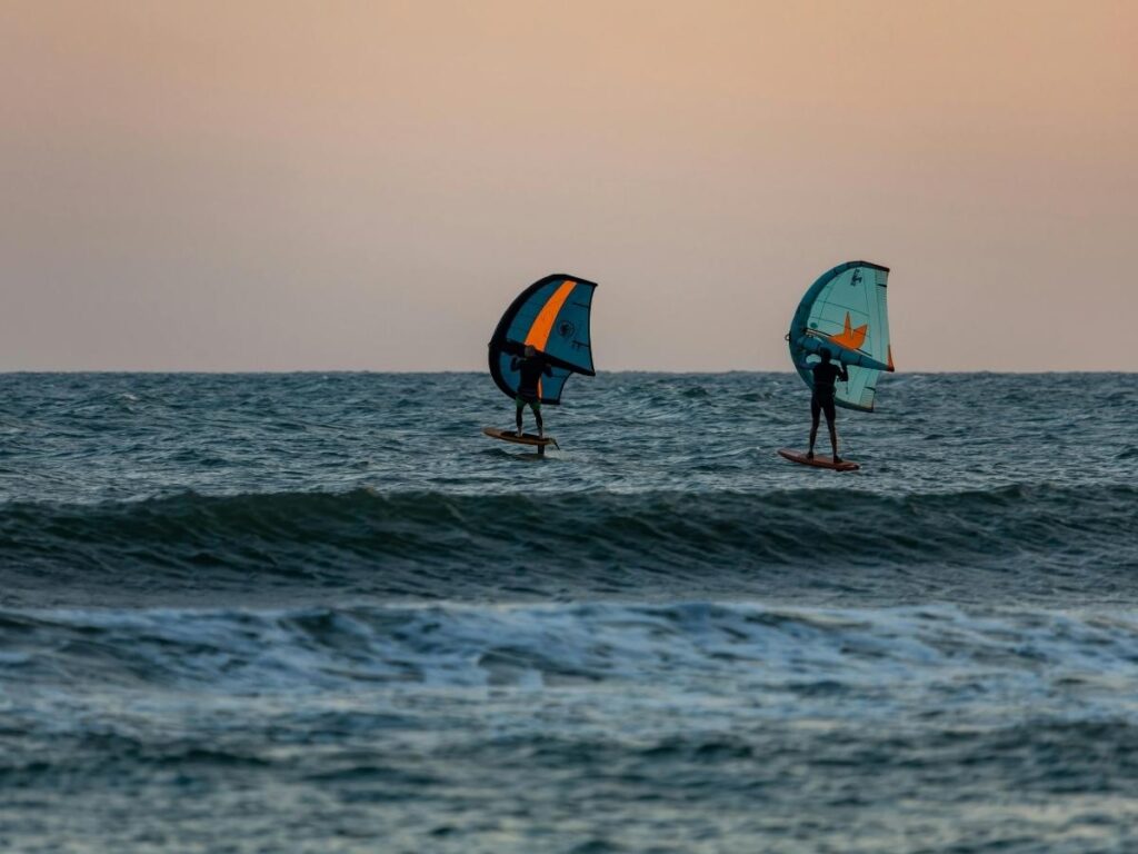 Windsurfer on Lake Garda with Riva del Garda’s lakeshore and mountains in the background.