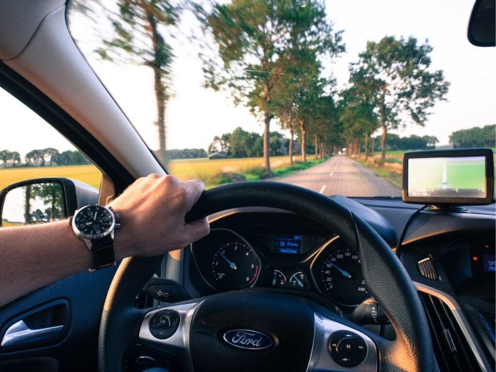 Car dashboard showing Google Maps navigation on screen