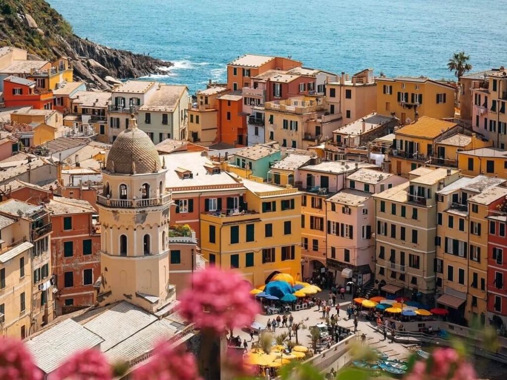 Hikers on the Sentiero Azzurro with sweeping coastal and vineyard views.