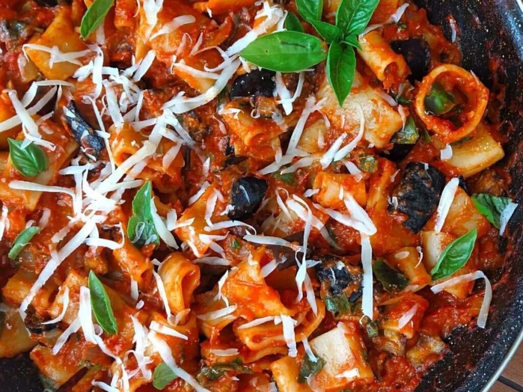 Classic Sicilian Pasta alla Norma topped with fried eggplant and grated ricotta salata