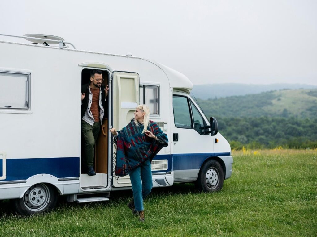 White tour van parked near a scenic viewpoint with travelers stepping out.
