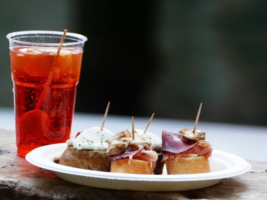 Plate of cicchetti with polpette and baccalà served with an Aperol Spritz