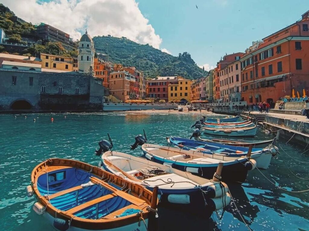 View of Vernazza’s small harbour and colorful boats from the castle lookout in Cinque Terre.