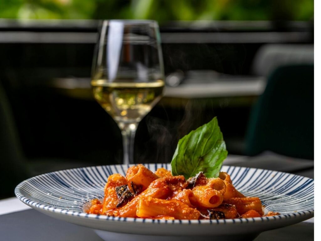 Traditional Sicilian lunch in Zafferana Etnea with fresh pasta, cheese, and a glass of Etna Rosso wine