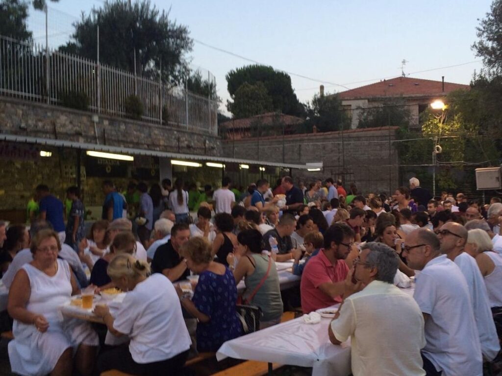 Handmade sign for a local sagra festival on a rural Abruzzo road, inviting travelers to stop and join.