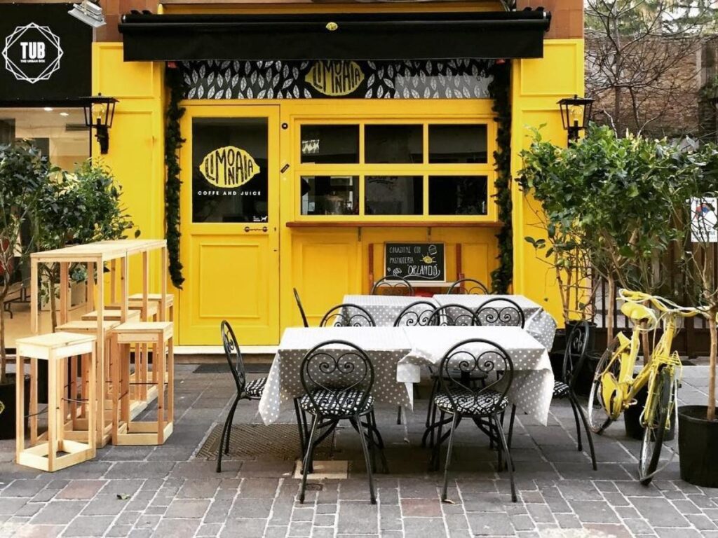 Traveler paying with coins at a small Abruzzo café counter with espresso cups lined up