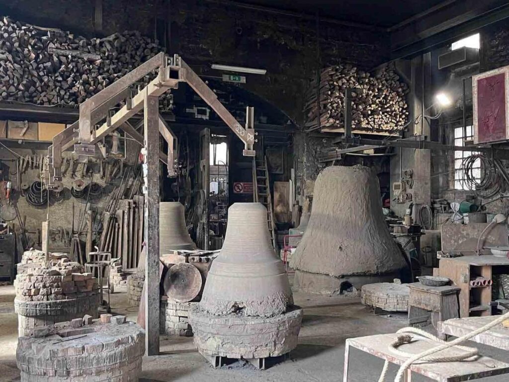 Craftsman inspecting a newly cast bronze bell inside the Marinelli Bell Foundry in Agnone.