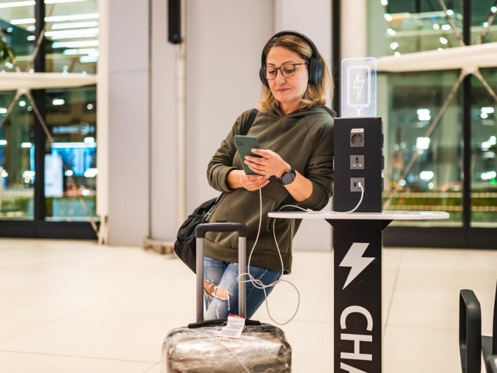 Airport charging zone with travelers using free Wi-Fi and power outlets