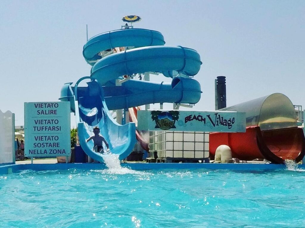 Visitors enjoying the wave pool and water slides at Aquafan Riccione on a sunny day