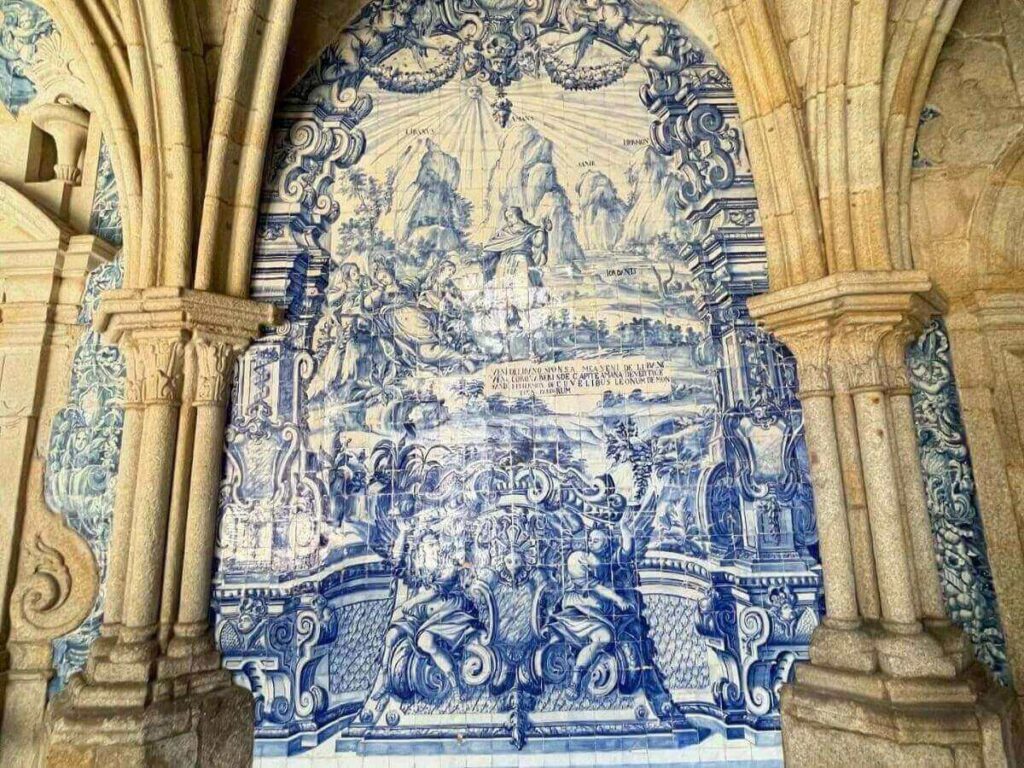 Close-up of hands painting a blue-and-white azulejo tile in a small Lisbon workshop