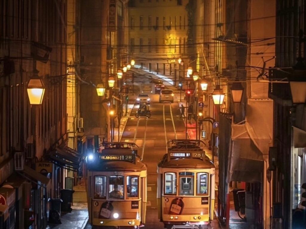 Wide view of Lisbon’s Baixa and Chiado districts with pastel buildings, tram tracks, and café terraces