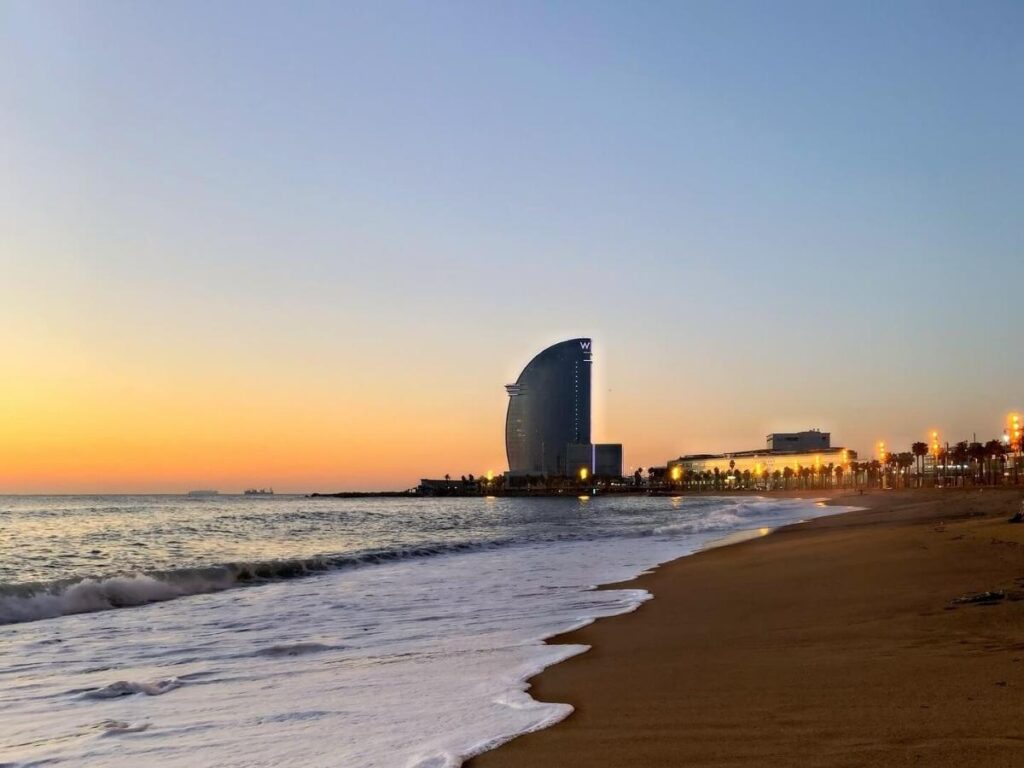 “Fishermen and small boats on Barceloneta shore at dawn
