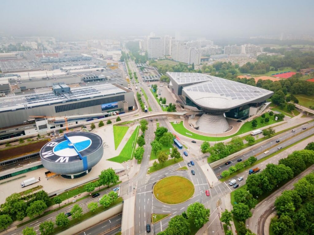 Futuristic façade of BMW Welt reflecting blue sky and cityscapes