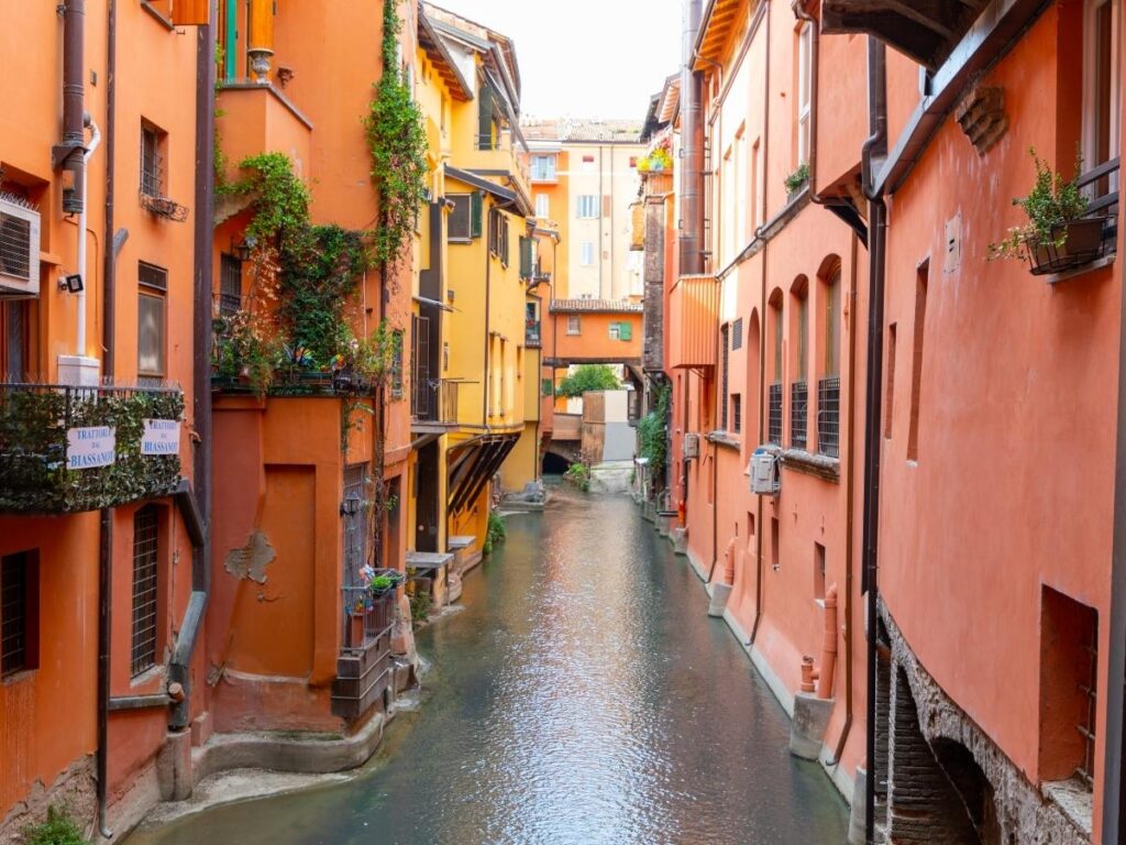 Reflections on the Canale di Reno with old buildings and a small bridge, Bologna”