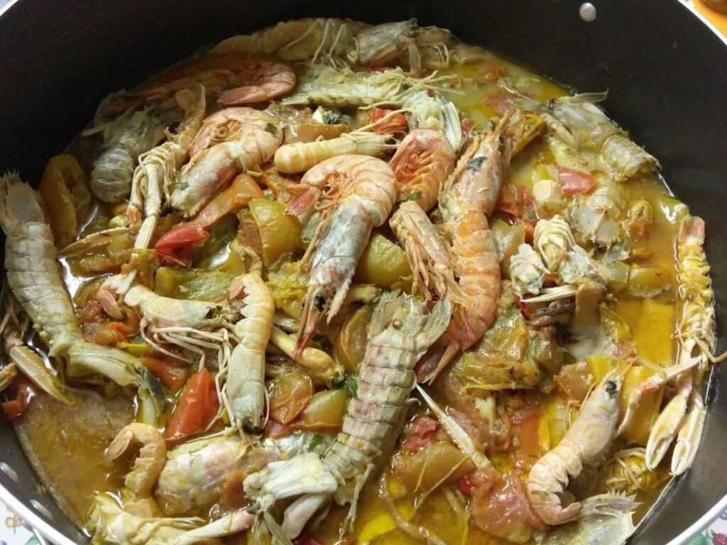 A steaming bowl of brodetto fish stew served with crusty bread at a seaside restaurant in Termoli.